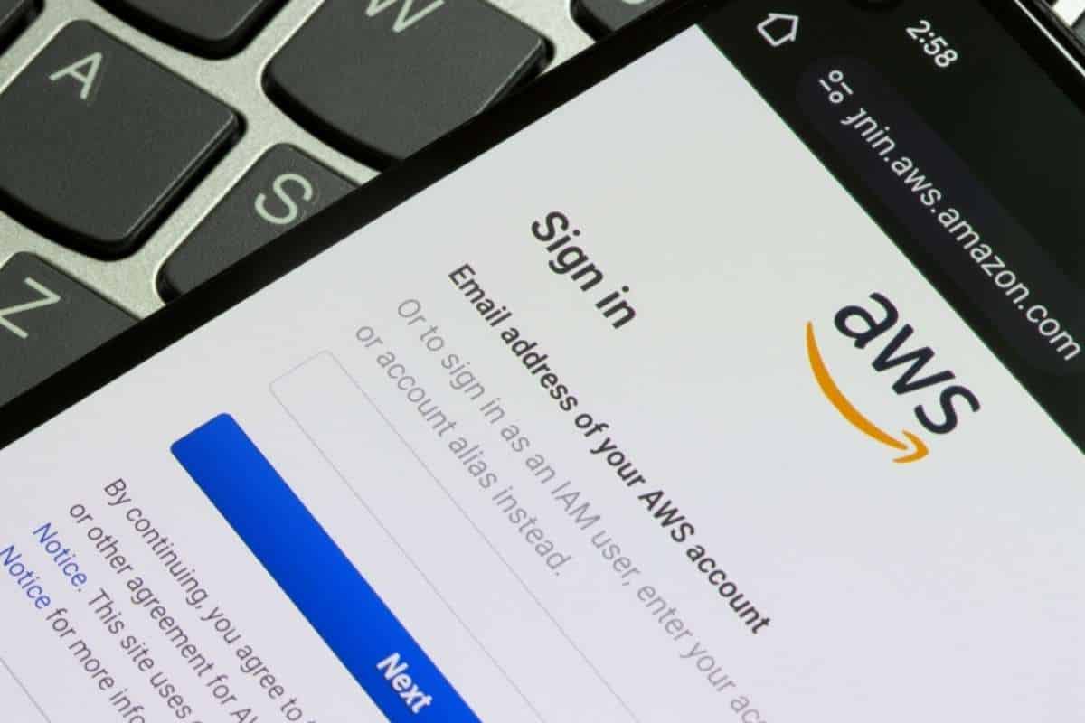 smartphone con pagina di iscrizione ad amazon web services su tastiera laptop