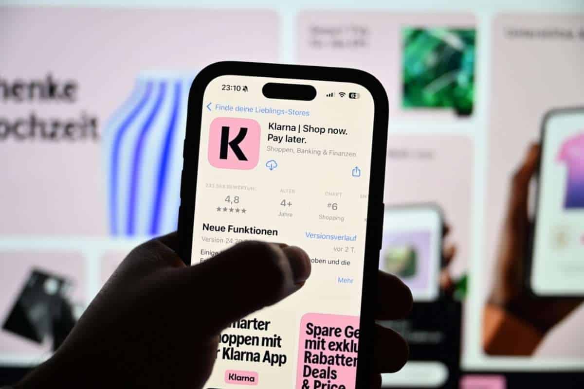 Mano che stringe smartphone con applicazione klarna su store