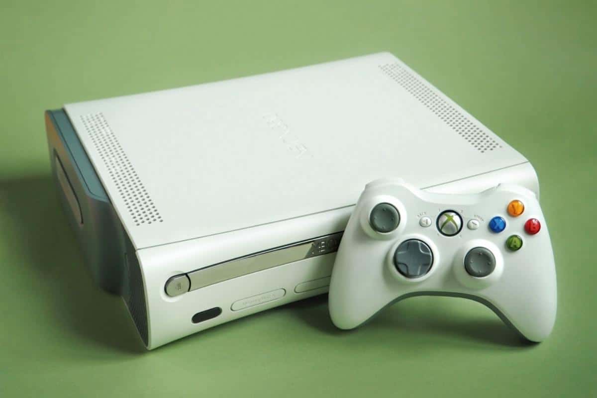 La consolle Xbox 360 con un controller su sfondo verde