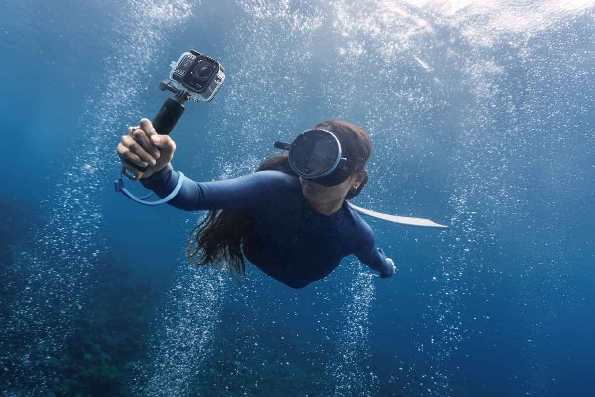 Donna sott'acqua con Insta360 Ace Pro 2 in mano