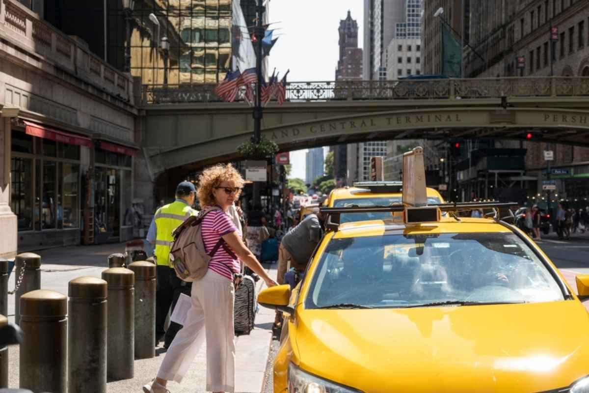 Donna che prende un taxi durante un viaggio organizzato con l'AI