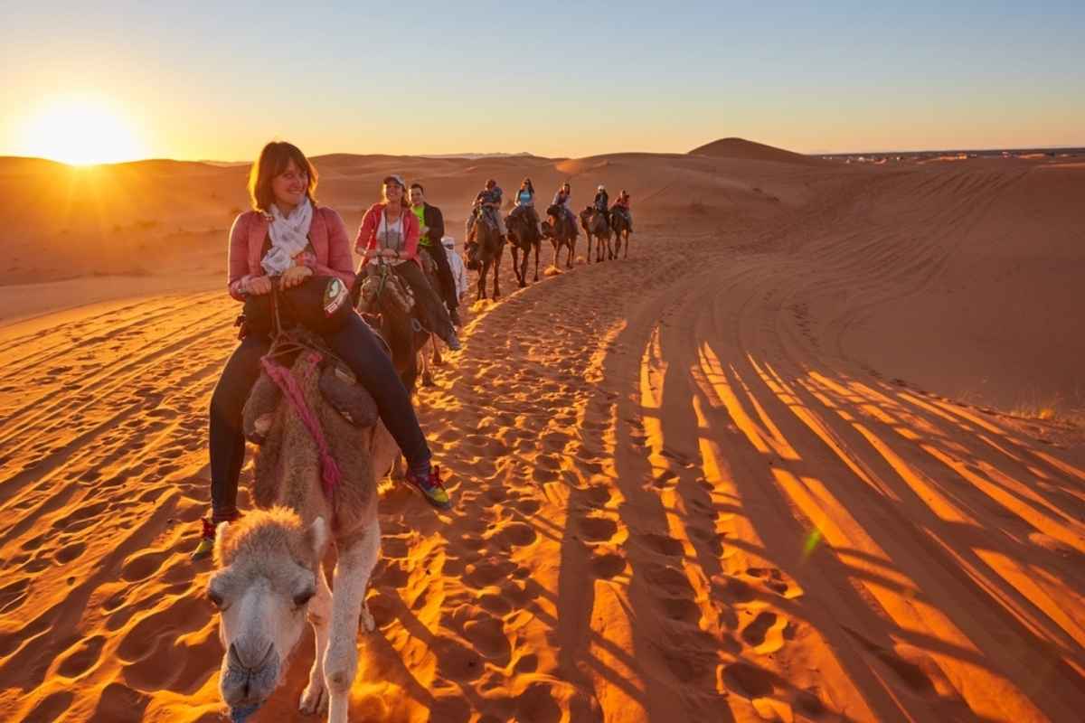 Gruppo di persone su cammelli nel deserto