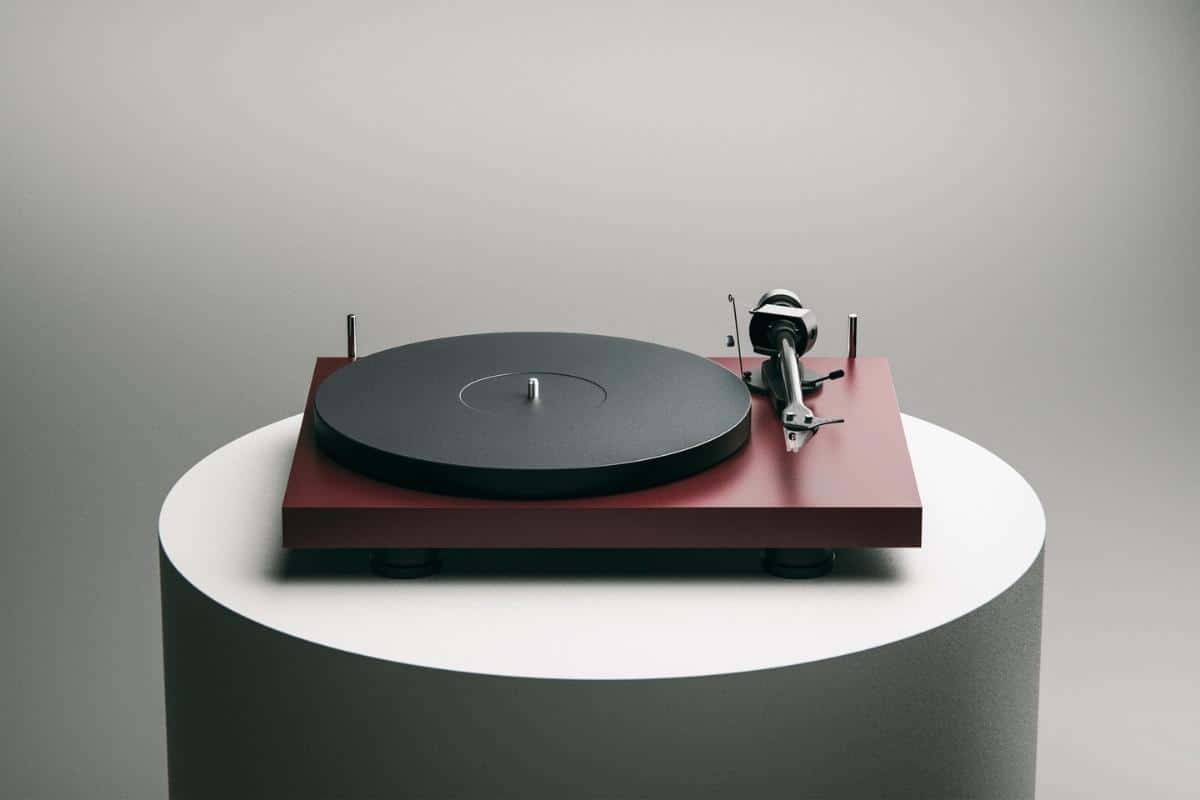 Pro-Ject Debut Carbon Evo 2 in versione rosso satinato su tavolo bianco con sfondo grigio