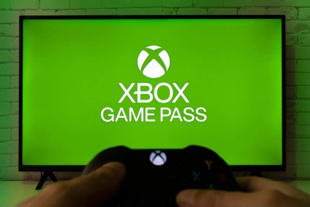 Xbox Game Pass su schermo in sfondo e controller in primo piano