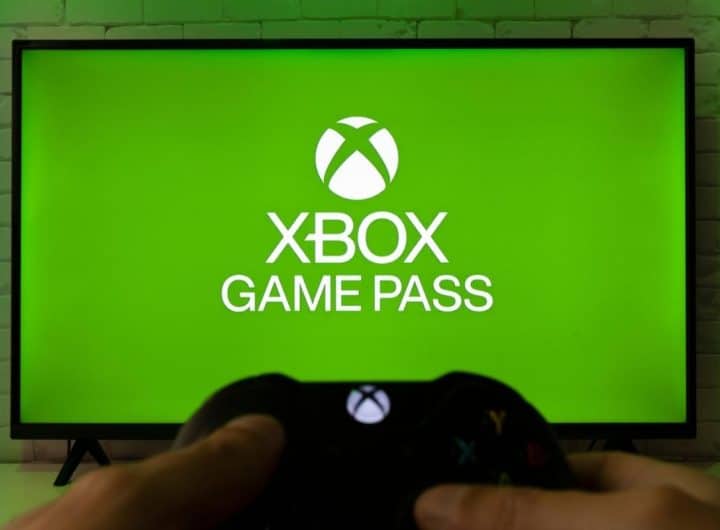 Xbox Game Pass su schermo in sfondo e controller in primo piano